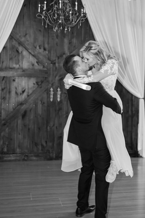 Wedding reception setup with string lights and barn beams